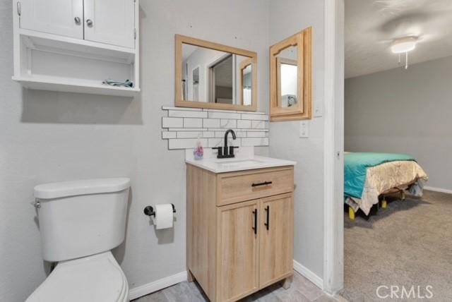 25624 Castlerock Rd, Apple Valley, CA 92308 - bathroom with vanity, toilet, tasteful backsplash, baseboards, and ensuite bath