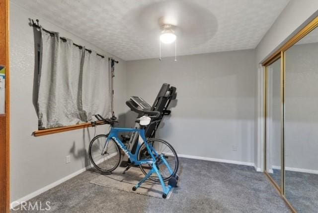 25624 Castlerock Rd, Apple Valley, CA 92308 - workout room with a textured ceiling, carpet flooring, and baseboards