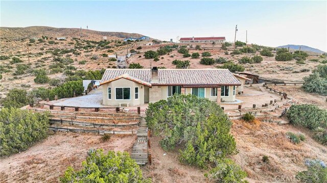 25624 Castlerock Rd, Apple Valley, CA 92308 - view of front of property featuring a chimney, a tiled roof, stucco siding, a mountain view, and stairway