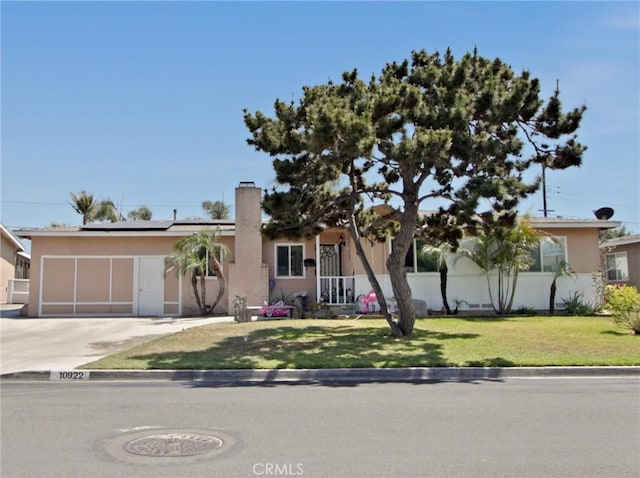 10922 Vickers Dr, Garden Grove, CA 92840 - ranch-style house with roof mounted solar panels, stucco siding, a chimney, a front lawn, and driveway