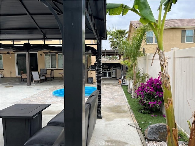 view of pool featuring fence, a ceiling fan, and a patio area