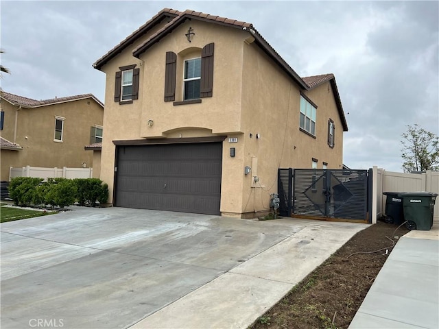 view of property exterior with concrete driveway, an attached garage, stucco siding, and fence