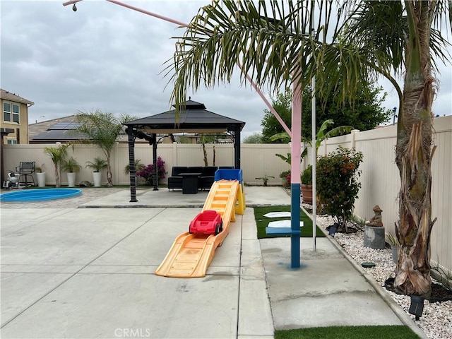 view of jungle gym featuring a gazebo, a patio area, a fenced backyard, and an outdoor living space
