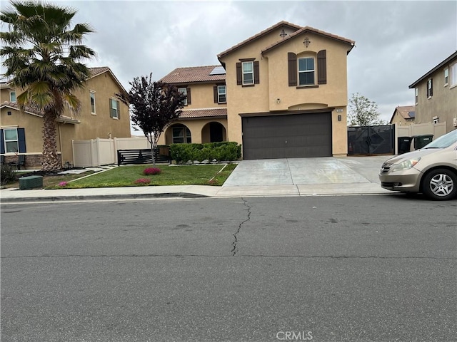 mediterranean / spanish home featuring a garage, stucco siding, fence, driveway, and a tiled roof