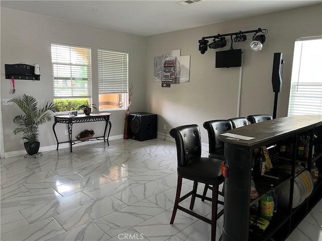 dining space with light marble finish floors and baseboards