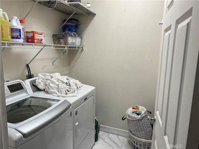 laundry area with washer and dryer, light marble finish floors, and baseboards