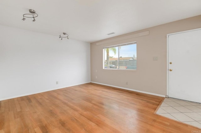 unfurnished room with light wood-style floors and baseboards