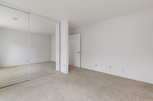 unfurnished bedroom with carpet and a closet