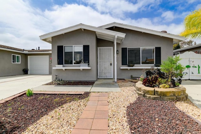 view of front of home featuring stucco siding, driveway, and a garage