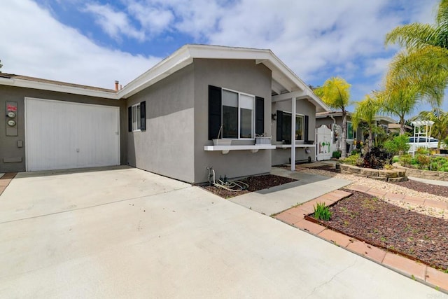 view of front of home with concrete driveway, stucco siding, and a garage