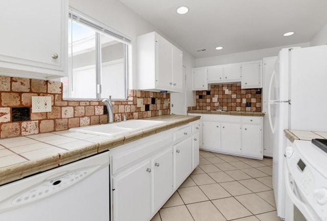kitchen featuring dishwasher, range, a sink, white cabinets, and recessed lighting