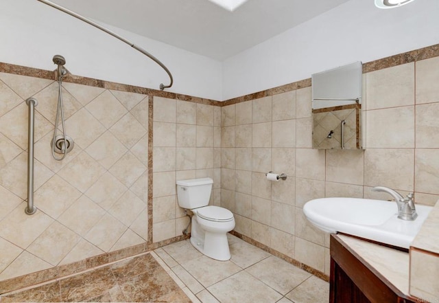 full bath featuring tile walls, tiled shower, toilet, and vanity