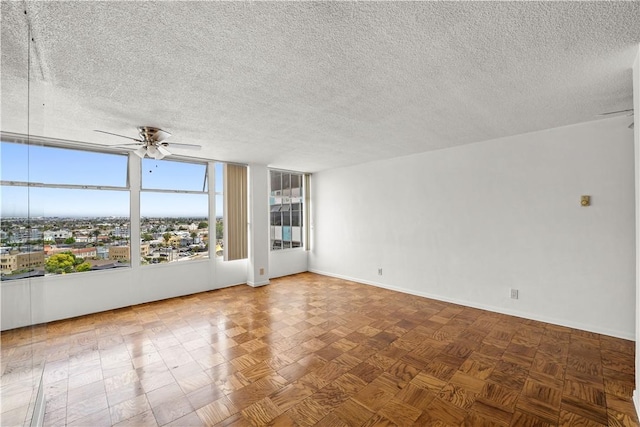 unfurnished room featuring ceiling fan, a textured ceiling, and baseboards