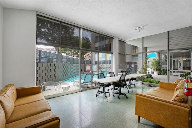 living area with floor to ceiling windows, plenty of natural light, and a textured ceiling