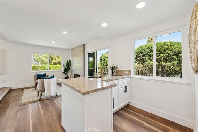529 Manzanita Rd, Redlands, CA 92373 - kitchen featuring a peninsula, baseboards, wood finished floors, light stone countertops, and white cabinets