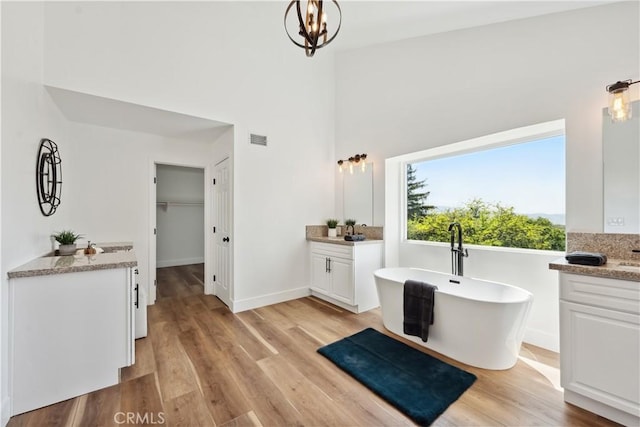 529 Manzanita Rd, Redlands, CA 92373 - full bath with a freestanding bath, two vanities, wood finished floors, a towering ceiling, and baseboards