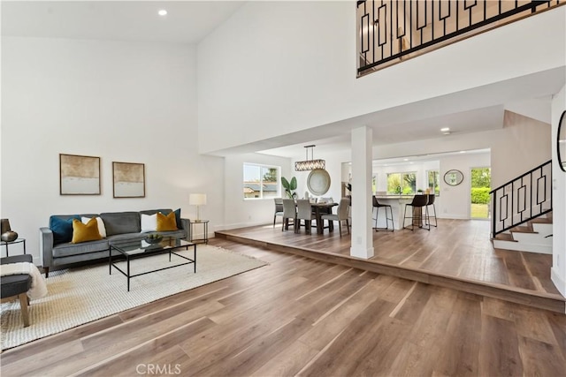 529 Manzanita Rd, Redlands, CA 92373 - living area featuring stairs, wood finished floors, plenty of natural light, a towering ceiling, and baseboards
