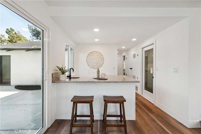 529 Manzanita Rd, Redlands, CA 92373 - kitchen featuring light stone countertops, dark wood finished floors, a peninsula, a breakfast bar, and recessed lighting