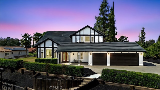 529 Manzanita Rd, Redlands, CA 92373 - tudor-style house with concrete driveway, stucco siding, a garage, and a tile roof