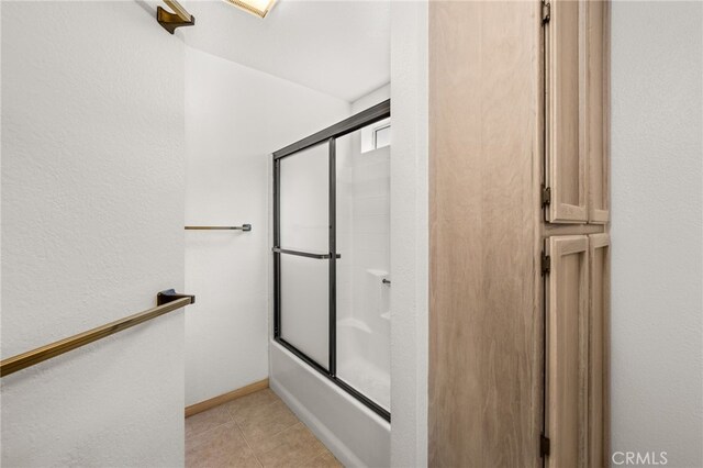 full bathroom with bath / shower combo with glass door and tile patterned floors
