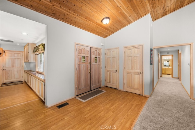 corridor featuring light wood-style flooring, recessed lighting, healthy amount of natural light, vaulted ceiling, and wood ceiling