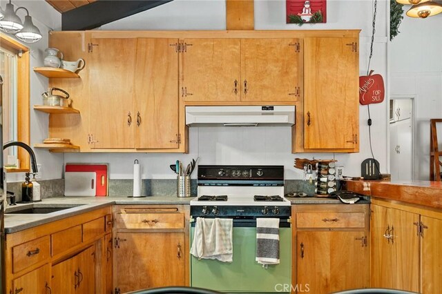 kitchen with white range with gas cooktop, under cabinet range hood, open shelves, and a sink