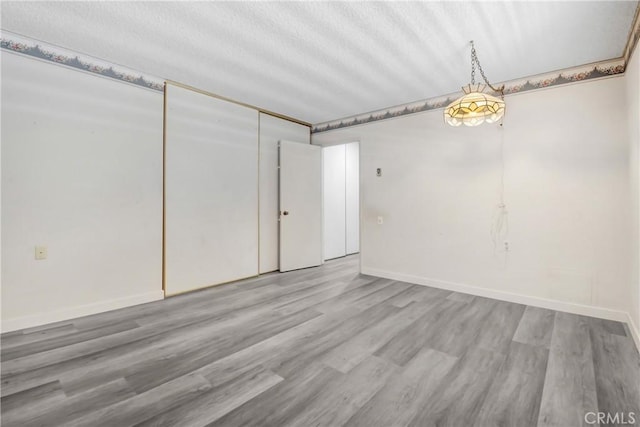 2384 Via Mariposa W Unit 3G, Laguna Woods, CA 92637 - spare room with wood finished floors, baseboards, and a textured ceiling