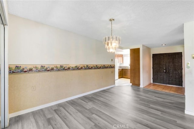 2384 Via Mariposa W Unit 3G, Laguna Woods, CA 92637 - empty room featuring wood finished floors, a chandelier, and baseboards