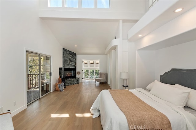 27757 N Bay Rd, Lake Arrowhead, CA 92352 - bedroom with high vaulted ceiling, access to exterior, wood finished floors, a fireplace, and recessed lighting