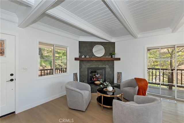 27757 N Bay Rd, Lake Arrowhead, CA 92352 - living area featuring beamed ceiling, a glass covered fireplace, healthy amount of natural light, wood finished floors, and baseboards