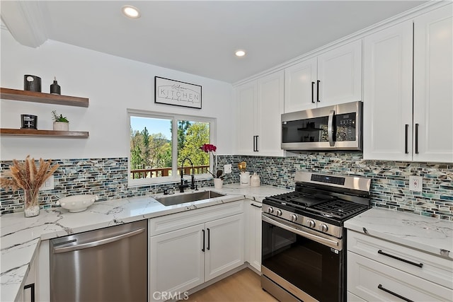 27757 N Bay Rd, Lake Arrowhead, CA 92352 - kitchen featuring appliances with stainless steel finishes, a sink, white cabinetry, decorative backsplash, and light stone countertops
