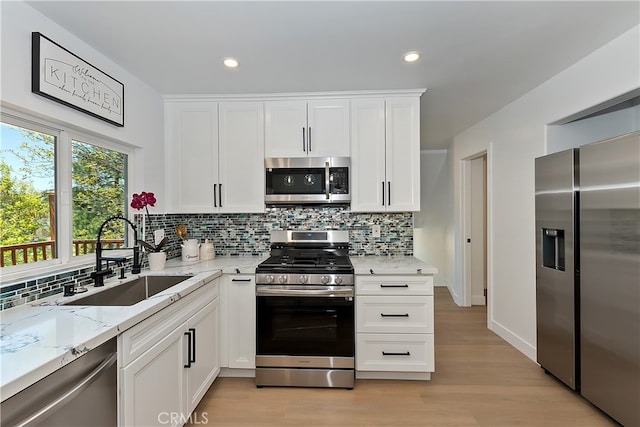 27757 N Bay Rd, Lake Arrowhead, CA 92352 - kitchen with stainless steel appliances, a sink, light stone countertops, backsplash, and light wood-type flooring