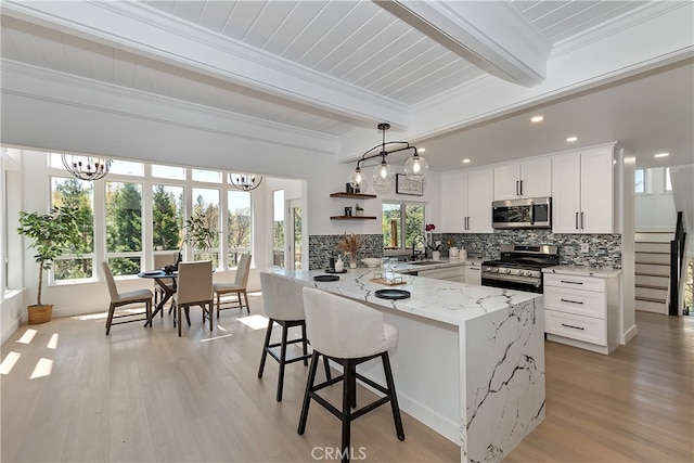 27757 N Bay Rd, Lake Arrowhead, CA 92352 - kitchen with appliances with stainless steel finishes, beam ceiling, a chandelier, tasteful backsplash, and a peninsula