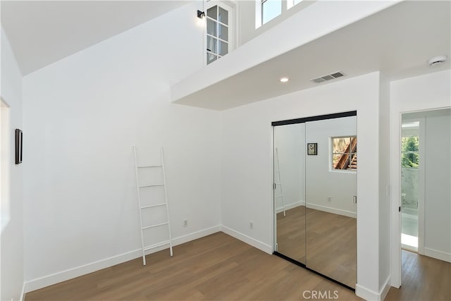 27757 N Bay Rd, Lake Arrowhead, CA 92352 - unfurnished bedroom with wood finished floors, a high ceiling, a closet, and baseboards