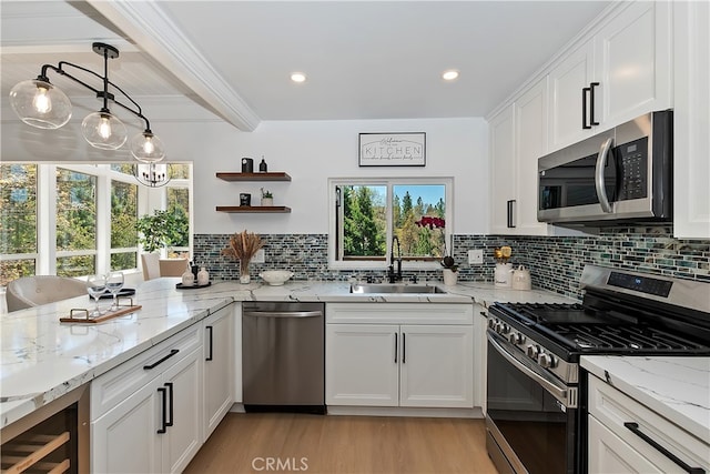 27757 N Bay Rd, Lake Arrowhead, CA 92352 - kitchen with appliances with stainless steel finishes, a sink, light wood-style floors, white cabinetry, and healthy amount of natural light