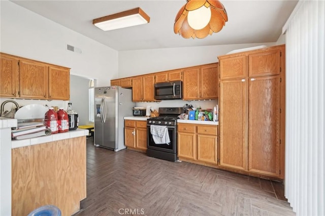 2925 Greenbriar Dr, Ontario, CA 91761 - kitchen with appliances with stainless steel finishes, brown cabinetry, tile counters, and high vaulted ceiling