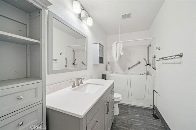 2925 Greenbriar Dr, Ontario, CA 91761 - bathroom with vanity, wood finished floors, toilet, and washtub / shower combination