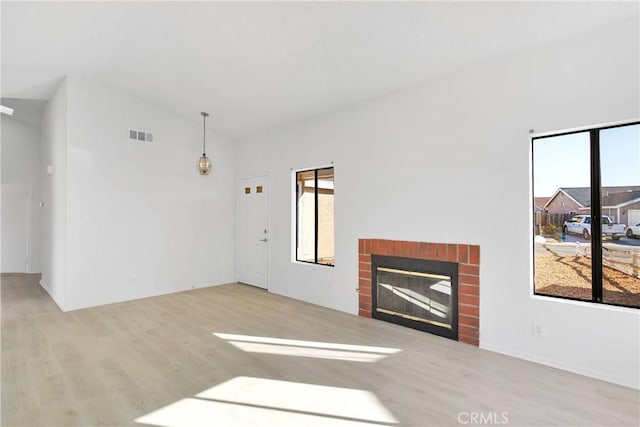 14359 Birchwood Dr, Hesperia, CA 92344 - unfurnished living room featuring wood finished floors, vaulted ceiling, and a brick fireplace