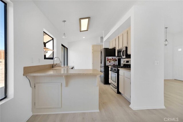 14359 Birchwood Dr, Hesperia, CA 92344 - kitchen with appliances with stainless steel finishes, a sink, light wood finished floors, a peninsula, and lofted ceiling