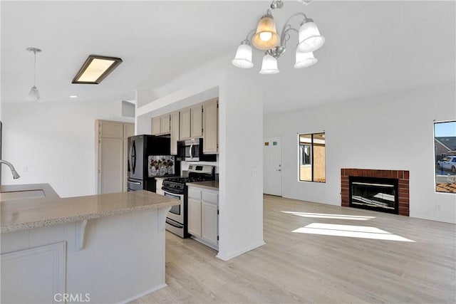 14359 Birchwood Dr, Hesperia, CA 92344 - kitchen featuring appliances with stainless steel finishes, a sink, a chandelier, light wood-style flooring, and light countertops