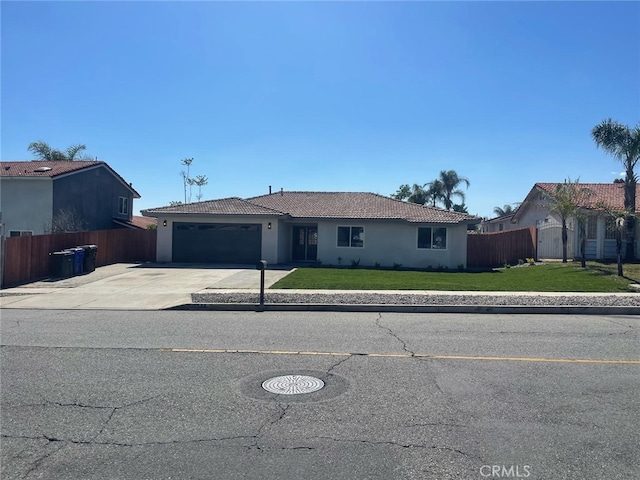 ranch-style house with a tile roof, a garage, driveway, and stucco siding