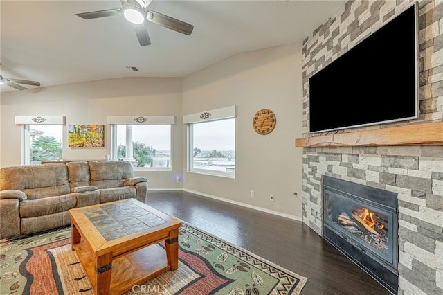 living room with ceiling fan, vaulted ceiling, a fireplace, wood finished floors, and baseboards