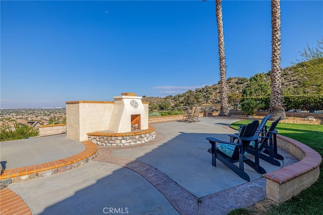 view of patio with an outdoor fireplace