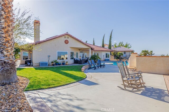 rear view of house featuring a patio, stucco siding, central AC, and a yard