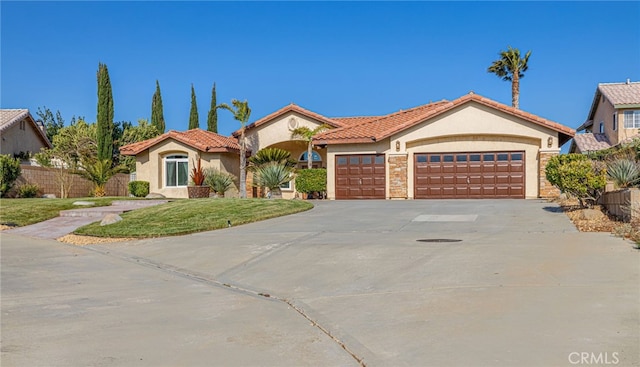 mediterranean / spanish-style house featuring stucco siding, driveway, a garage, and a tiled roof