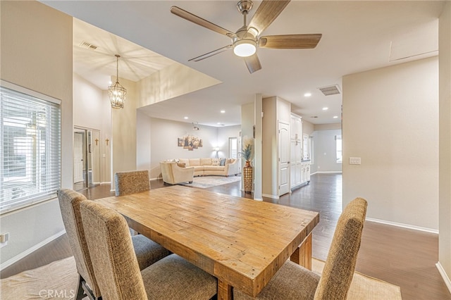 dining space with baseboards, dark wood-style floors, ceiling fan, recessed lighting, and a chandelier