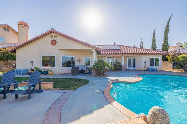 view of swimming pool with french doors, a patio, and central air condition unit