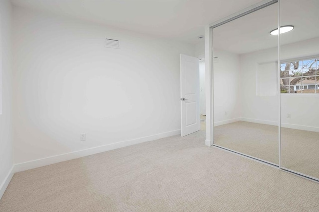 unfurnished bedroom with a closet, carpet flooring, and baseboards