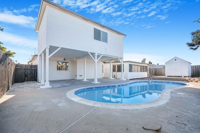 view of pool featuring a patio area, a fenced backyard, a shed, a sunroom, and an outdoor structure