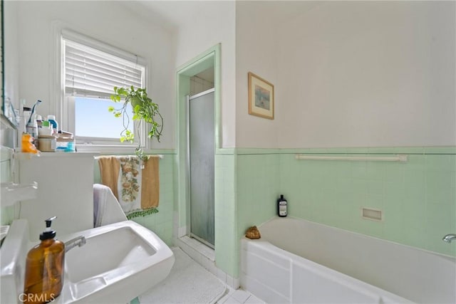 1801 N Ross St, Santa Ana, CA 92706 - bathroom featuring a shower stall, a bath, a wainscoted wall, tile patterned floors, and tile walls